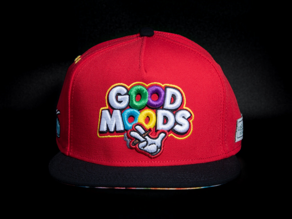Gorra snapback roja CAYLER & SONS con bordado colorido GOOD MOODS y visera plana negra sobre fondo oscuro